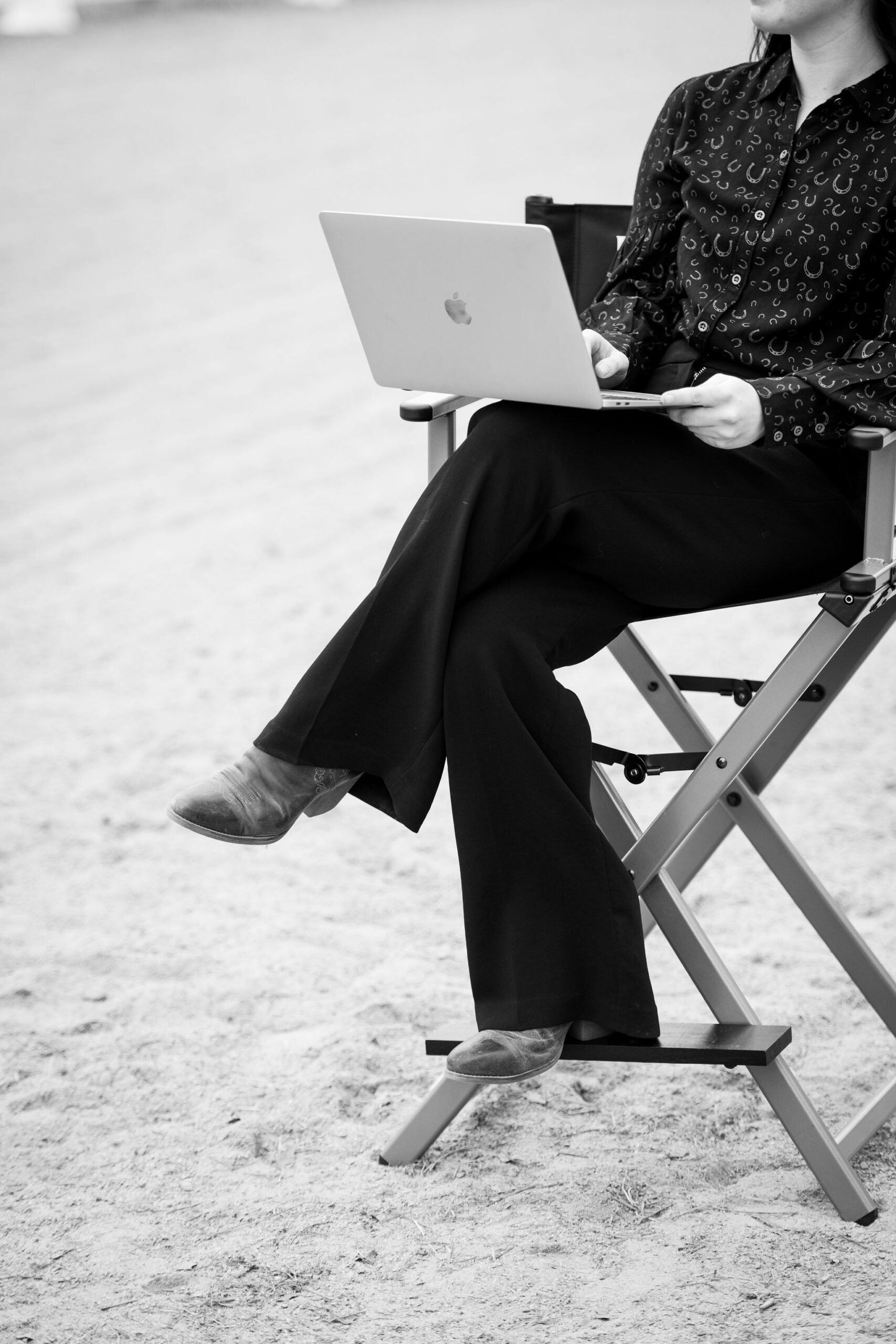 Girl on Directors Chair in Riding Arena on Laptop